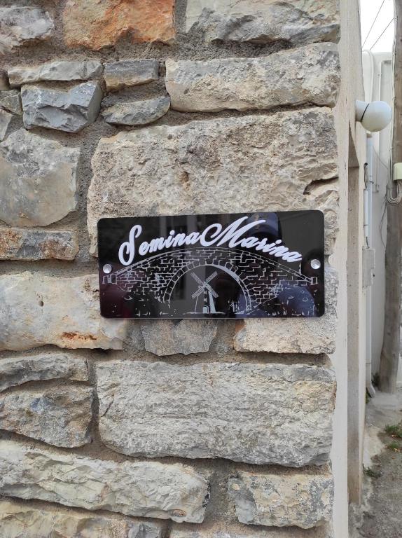 a sign on the side of a stone wall at Semina-Marina in Hersonissos