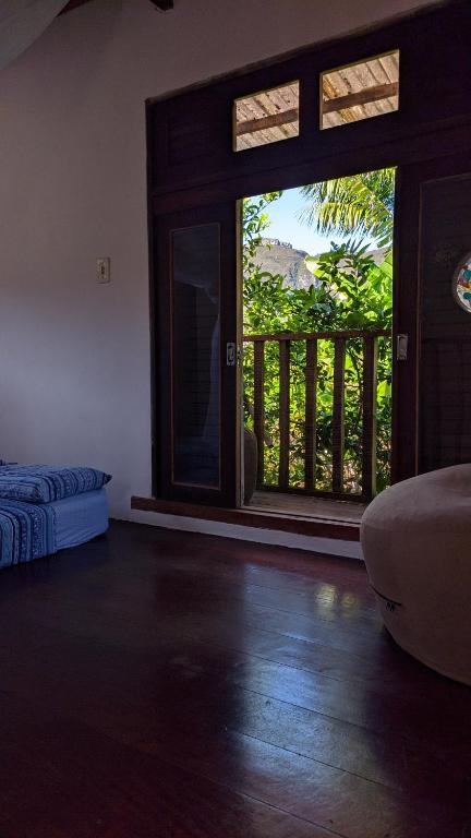 a room with a sliding glass door with a balcony at Cecilia & Pretinho's House in Vale do Capao