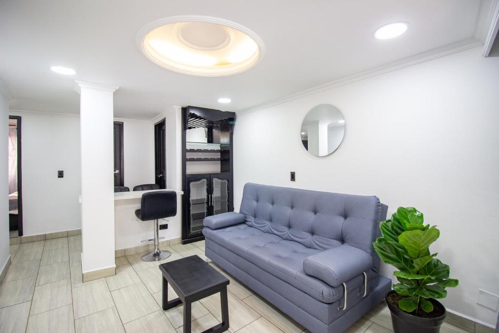 a living room with a blue couch and a table at Excelente apartamento cerca a parques turísticos in Medellín