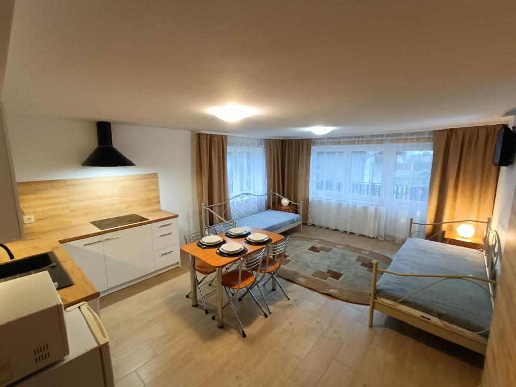 SzlachtowaにあるNa Wspólnejのテーブル、ベッド、キッチンが備わる小さな客室です。