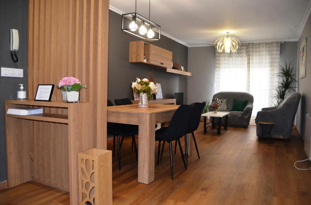 a dining room and living room with a table and chairs at REGO DA RAÑA APARTMENTS in Arzúa