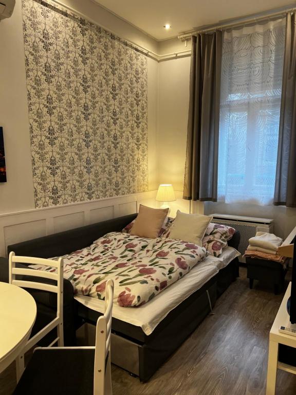 Pázmány Rest Apartman في بودابست: غرفة نوم بسرير وطاولة ونافذة