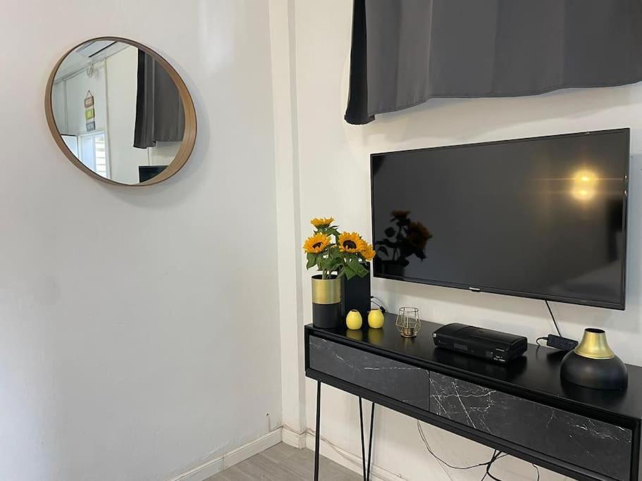 a living room with a television and a mirror at דירה גדולה יפיפיה קרובה לחוף הים in Tel Aviv