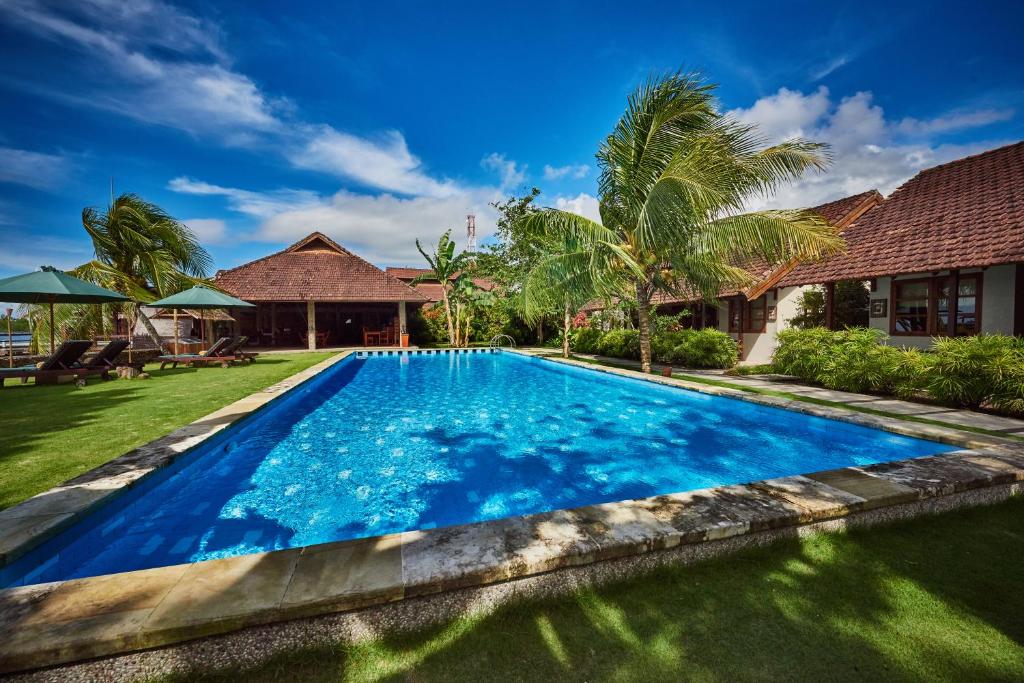 an image of a swimming pool in front of a house at Cocotinos Manado in Manado