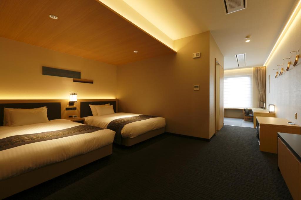 Cama ou camas em um quarto em Kanazawa Sainoniwa Hotel