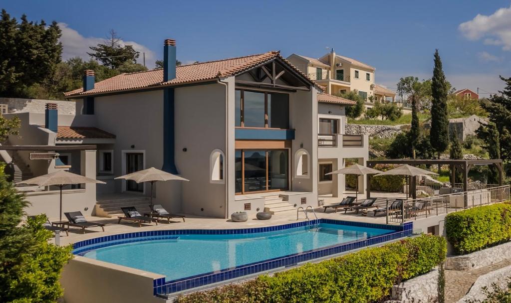 a villa with a swimming pool and a house at Luxury Villa Karmaniolos Fiskardo Kefalonia in Fiskardho