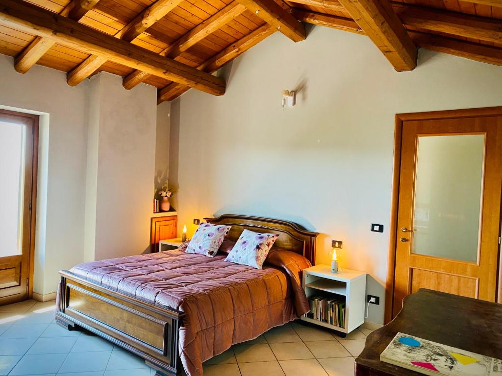 1 dormitorio con cama y techo de madera en Casa Vistabella, en Frassinello Olivola