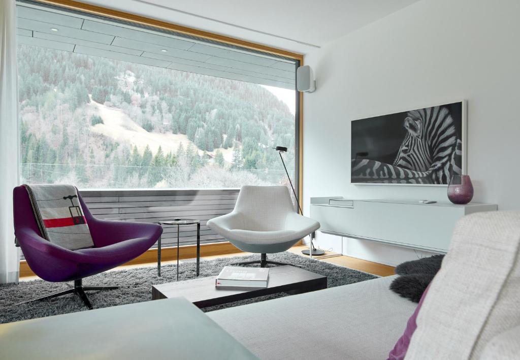 a living room with a couch and a chair and a large window at Design Villa M in Gortipohl