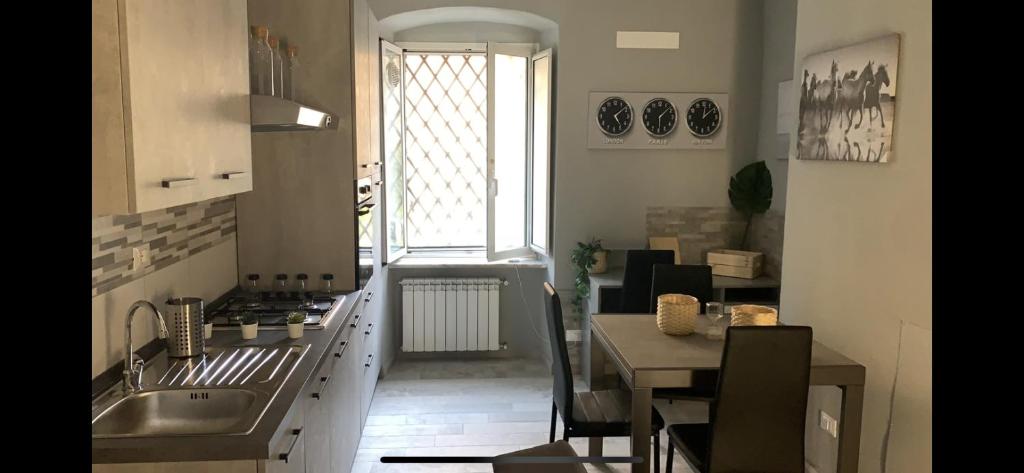 cocina con fregadero, mesa y ventana en Crystal Home, en La Spezia