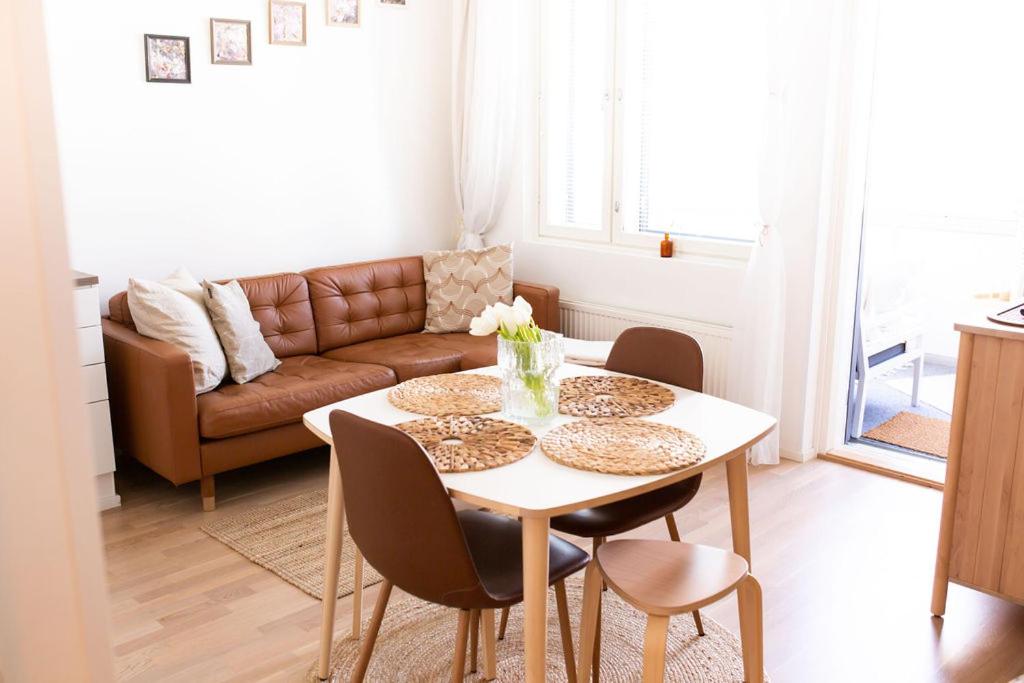 a living room with a table and a couch at Modern apartment with sauna and free parking in Kuopio