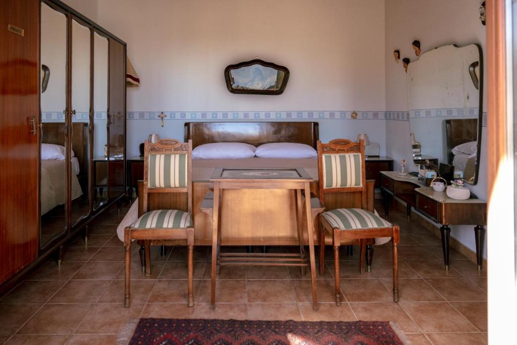 1 dormitorio con 1 cama, mesa y sillas en Tetti & Chiese - Authentic Sicilian Rooftop, en Catania