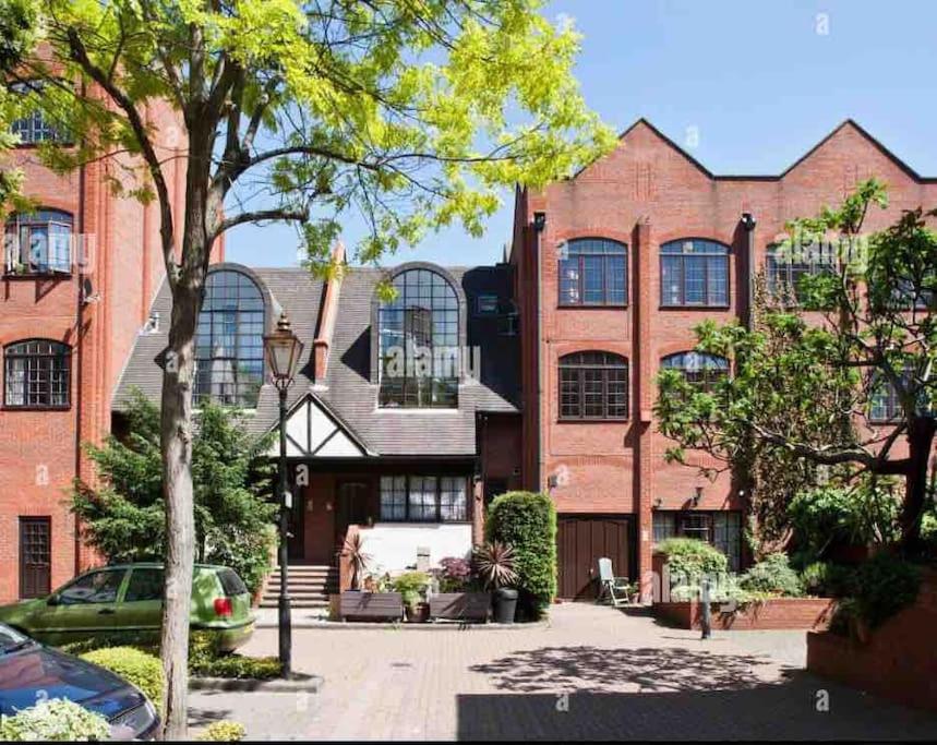 a large brick building with a car parked in front of it at Cosy and Stylish 1BD-Limehouse in London