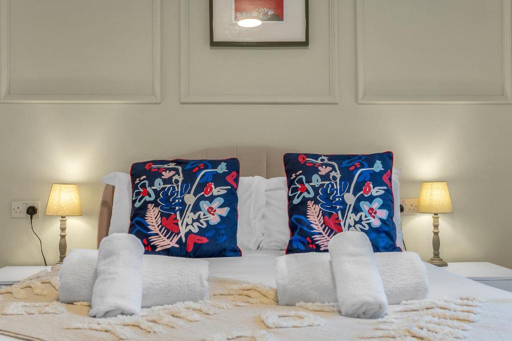een bed met handdoeken en 2 kussens bij Cheerful Stays - Jamson Pl 3 Bed Apartment in Edinburgh