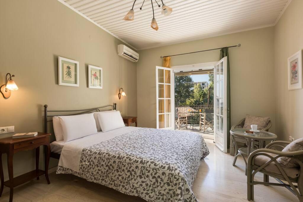 ein Schlafzimmer mit einem Bett und einer Tür zu einer Terrasse in der Unterkunft Villa Anthoussa in Palaiokastritsa in Korfu-Stadt