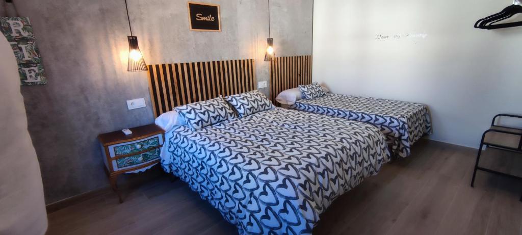 a bedroom with two beds and a table and lights at AniCa II, el lugar de la Mancha in Argamasilla de Alba