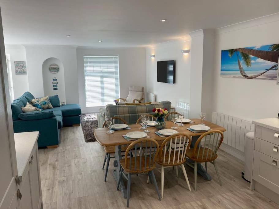 a kitchen and living room with a table and chairs at Surf's Up! Atlantic Reach, Nr Newquay, Cornwall. Perfect base for holidays or work in Saint Columb Major