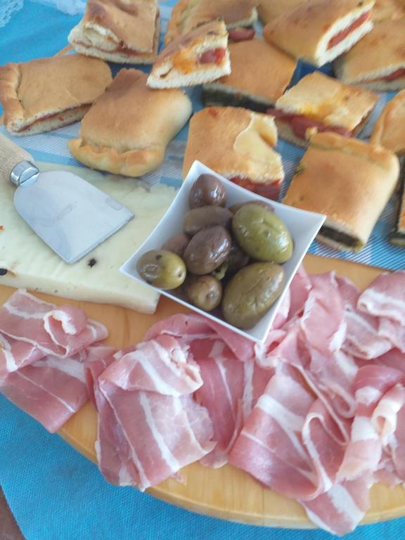 un plato de comida con jamón, queso y carne en B&B Solarium, en Marina di Noto