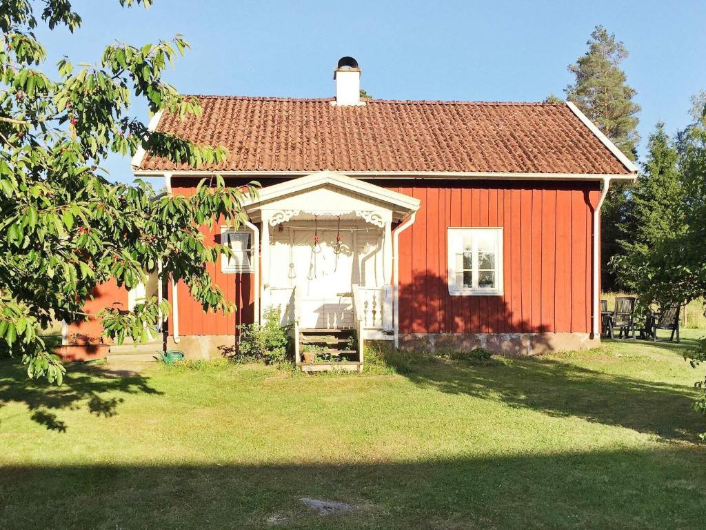 uma casa vermelha com um telhado vermelho e um jardim de relva em Holiday home ULRICEHAMN VI em Ulricehamn