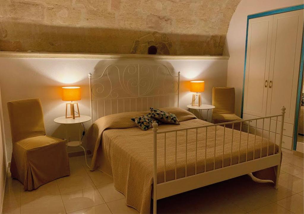 Al Vicoletto في جينوسا: غرفة نوم بسرير مع مصباحين وكرسي