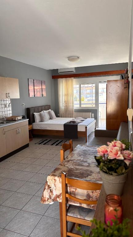 a living room with a bed and a table with flowers at Artemis Hotel Apartments in Keramoti