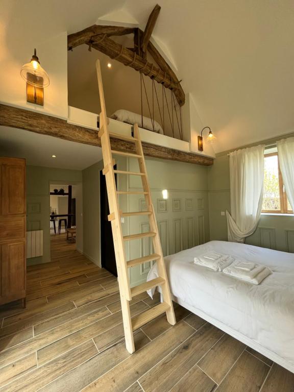 ein Schlafzimmer mit einem Etagenbett mit einer Leiter in der Unterkunft Ferme de la Tour Maurouard - Gîte indépendant entièrement équipé 