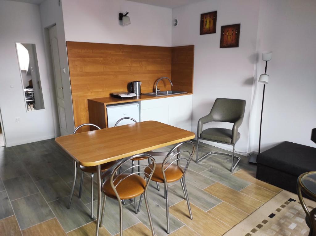 a kitchen and dining room with a table and chairs at Pod 4 in Ustronie Morskie