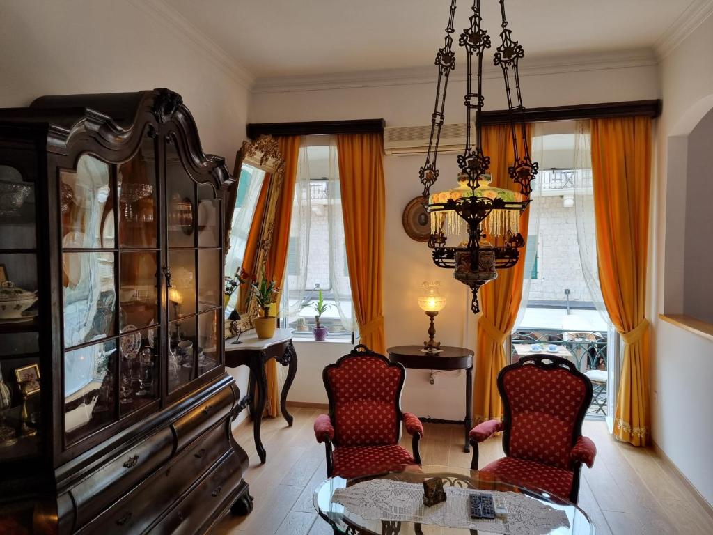 a living room with two chairs and a table and a chandelier at Main Square View in Kotor