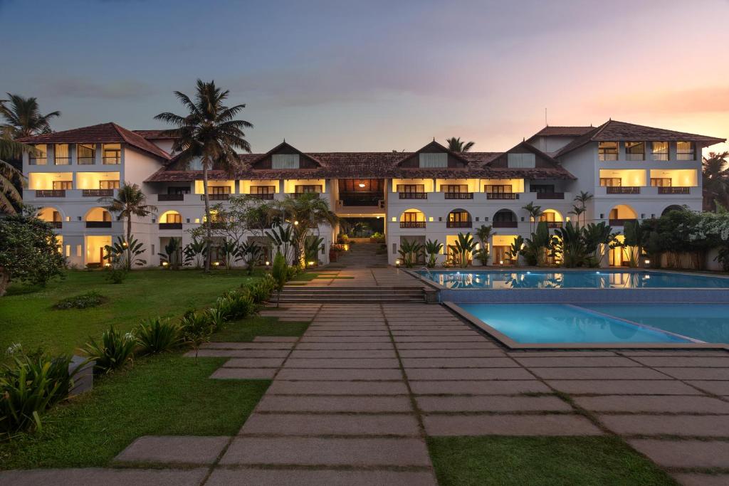 una vista exterior de un complejo con piscina en Estuary Sarovar Premiere Poovar Island, en Pūvār