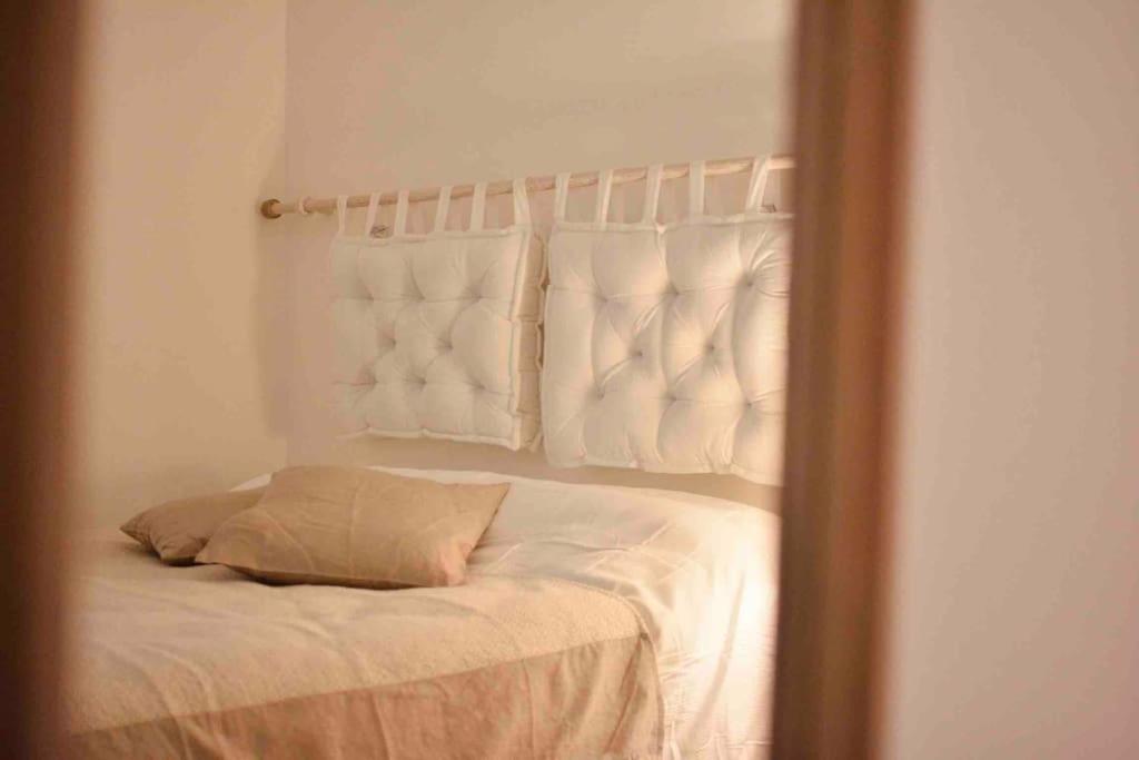 a reflection of a bed with white sheets and pillows at Una perla in pieno centro in Perugia