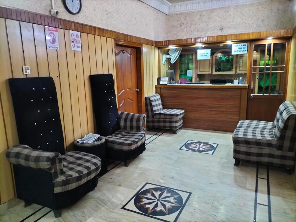 Jinnah Airport Hotel في كراتشي: غرفة انتظار مع ثلاثة كراسي وبار