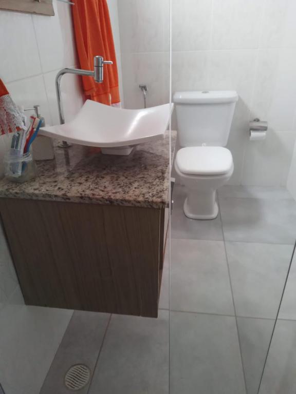 uma casa de banho com um WC branco e um lavatório. em CASA DA Lú em Alto Caparaó