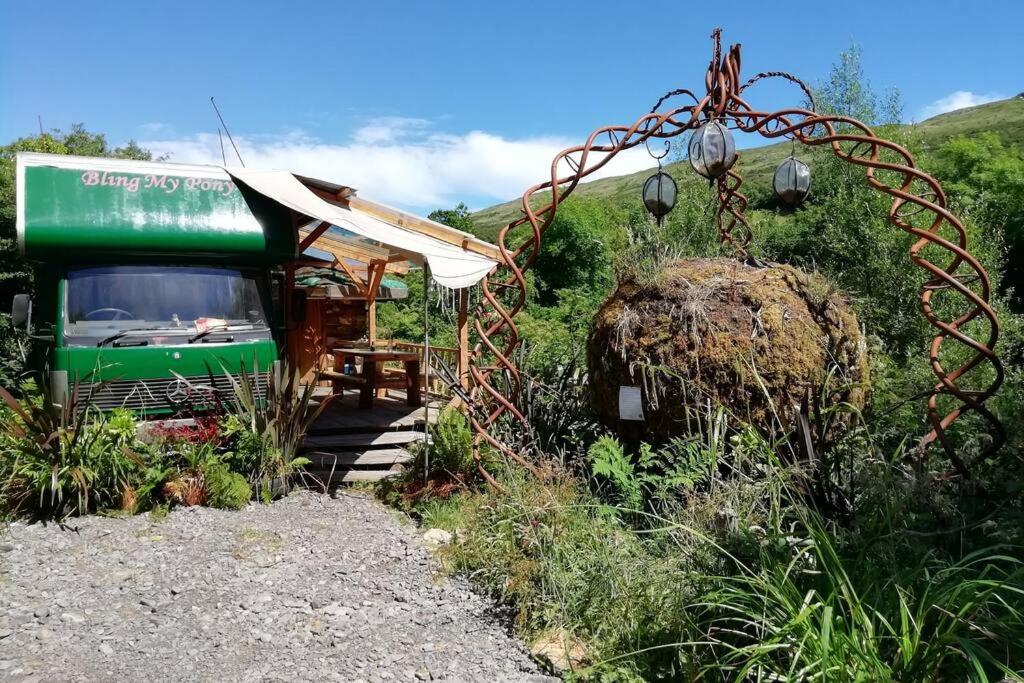 a green bus parked next to a small building at Truck & Pod creative nature retreat. in Bantry