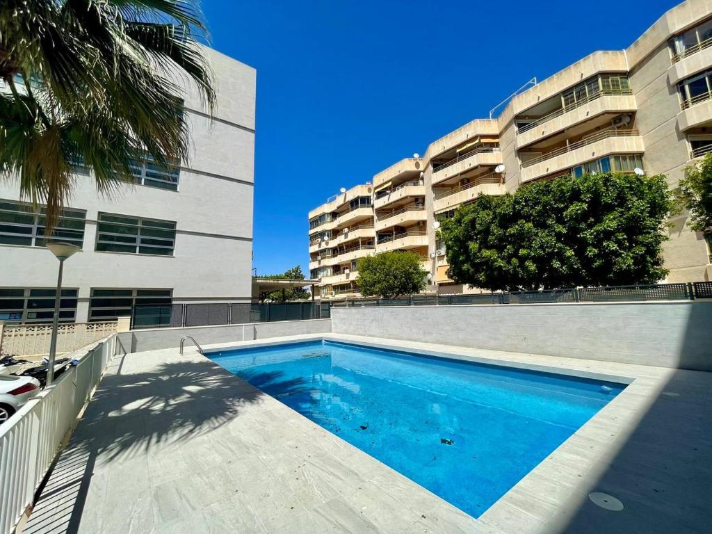 una piscina frente a un edificio en Portus apartment with pool, en Santa Pola