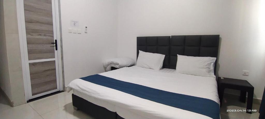 a bedroom with a large bed with a black headboard at Happy Beach For Studio Rooms Apartment in Aqaba