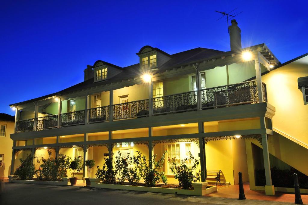 een groot wit gebouw met 's nachts verlichting bij Clifton Motel & Grittleton Lodge in Bunbury