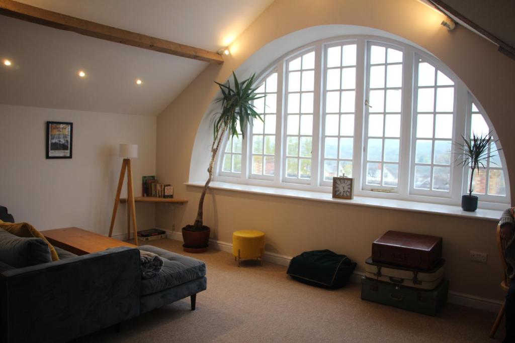 a living room with a couch and a large window at Clock Tower Apartment in Llandrindod Wells