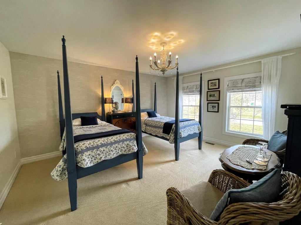 a bedroom with two beds and a table at Darlington House Bed and Breakfast in Niagara-on-the-Lake