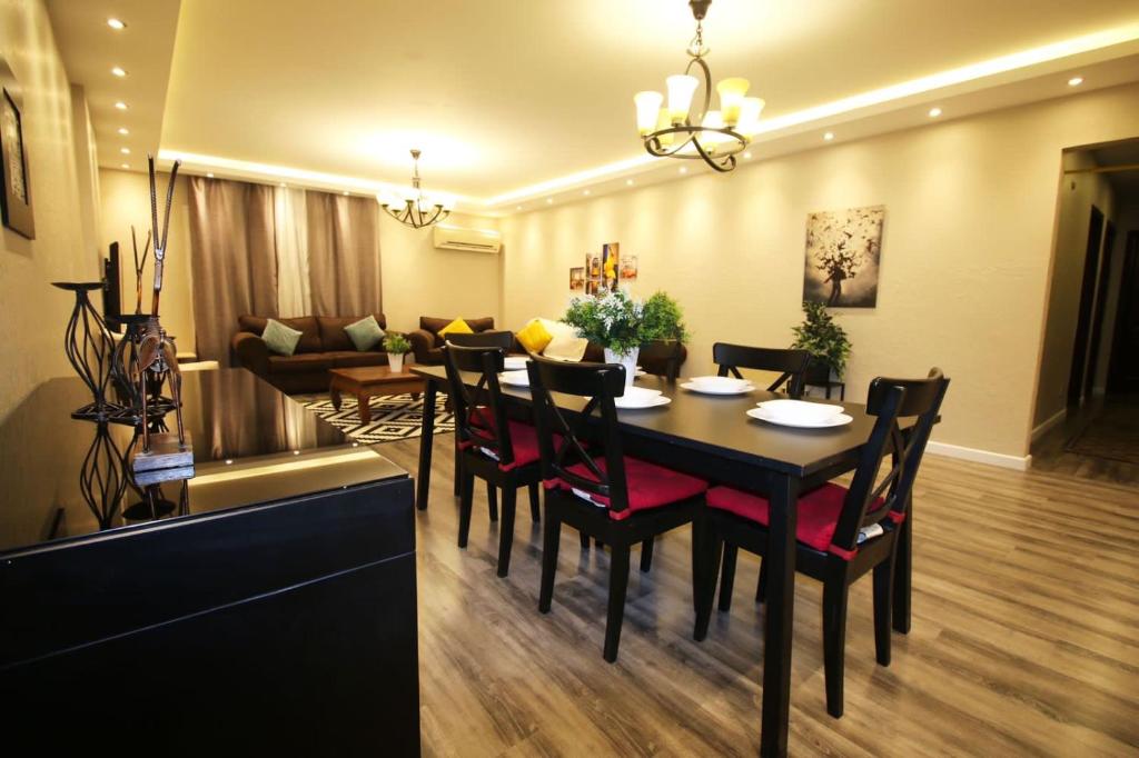 - une salle à manger avec une table, des chaises et un canapé dans l'établissement Sweet home in maadi, au Caire