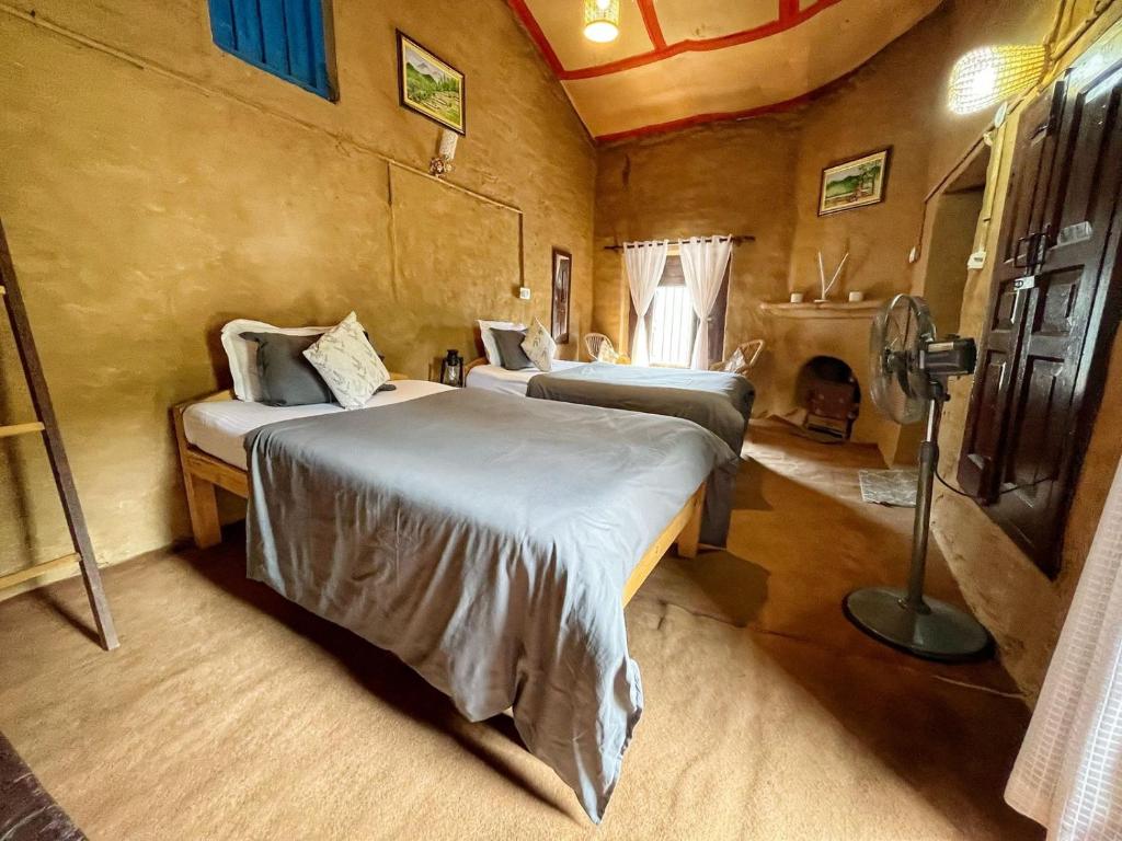 um quarto com duas camas num quarto em Kurmanchal Village by THE GHAUR em Almora