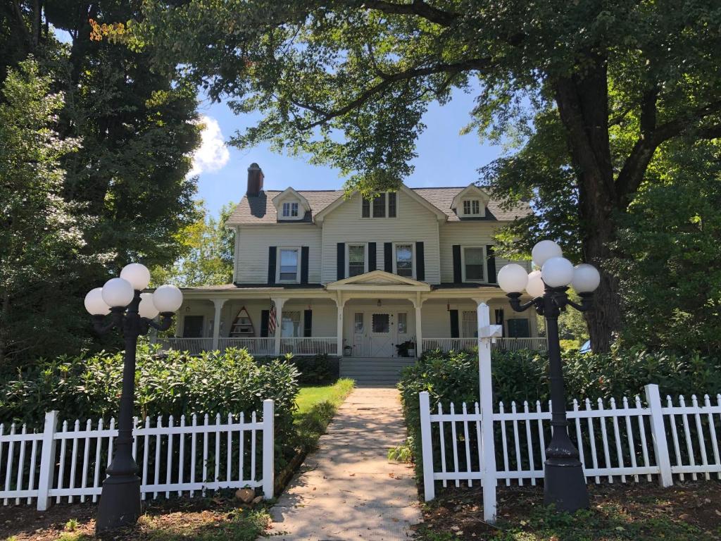 una cerca blanca frente a una casa con dos luces en Love Lane Bed & Breakfast, en Waynesville