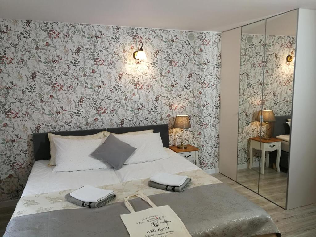 a bedroom with a large bed with floral wallpaper at Willa Łysica in Krynica Morska