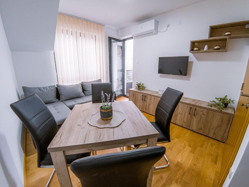 - un salon avec une table et des chaises en bois dans l'établissement Apartman Bellini 2, à Sokobanja