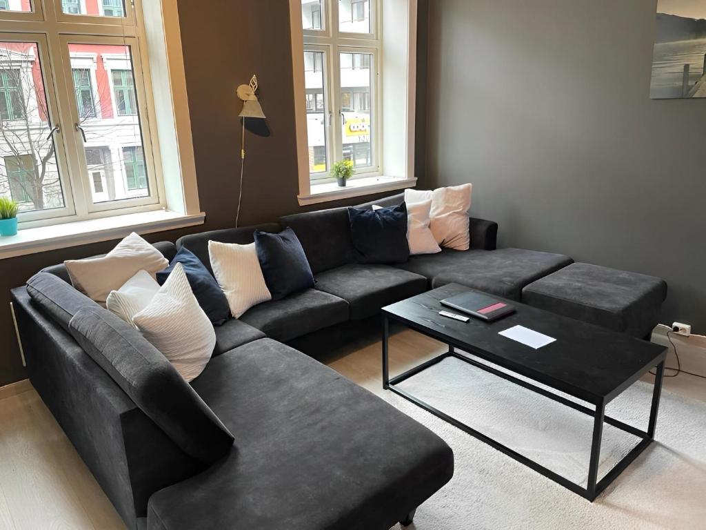 a living room with a black couch and a table at 4 bedroom flat in the heart of Oslo in Oslo