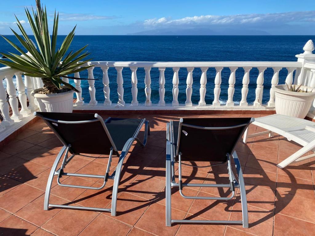un tavolo e sedie su un balcone con vista sull'oceano di 1st Line Sea View & Rooftop - Arena a Puerto de Santiago
