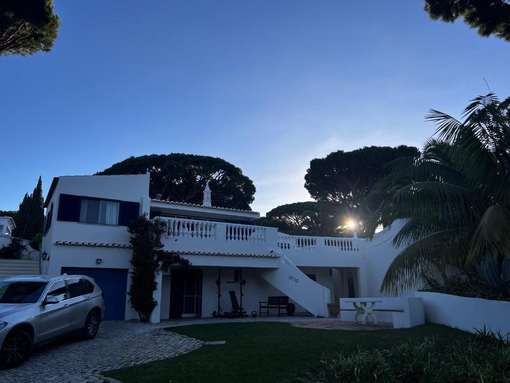 ein weißes Haus mit einem Auto in der Einfahrt in der Unterkunft Royal Course Villa, Vale do Lobo in Vale do Lobo