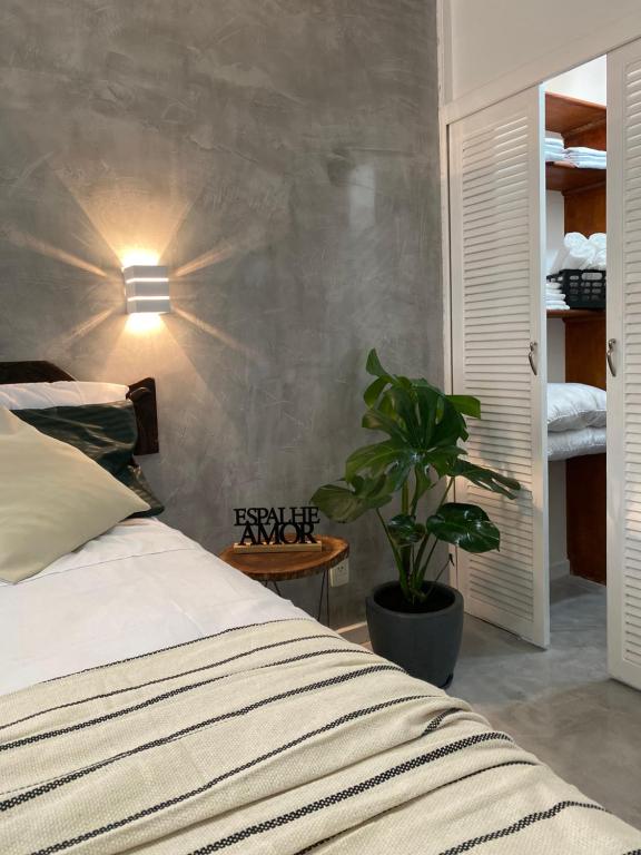 1 dormitorio con 1 cama y una maceta en Lifestyle Carioca Pontal Recreio, en Río de Janeiro
