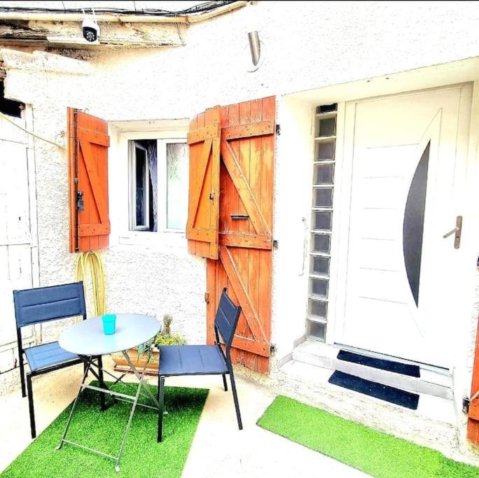 a patio with a table and chairs and a door at Charmant appart 4Per Marseille in Marseille