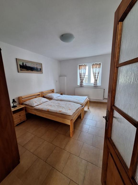 een slaapkamer met een bed en 2 ramen bij Chalupa u Šobrů 