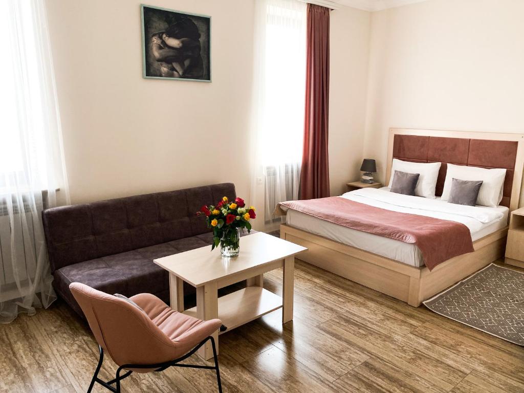 Alex Hotel في يريفان: غرفه فندقيه بسرير واريكه