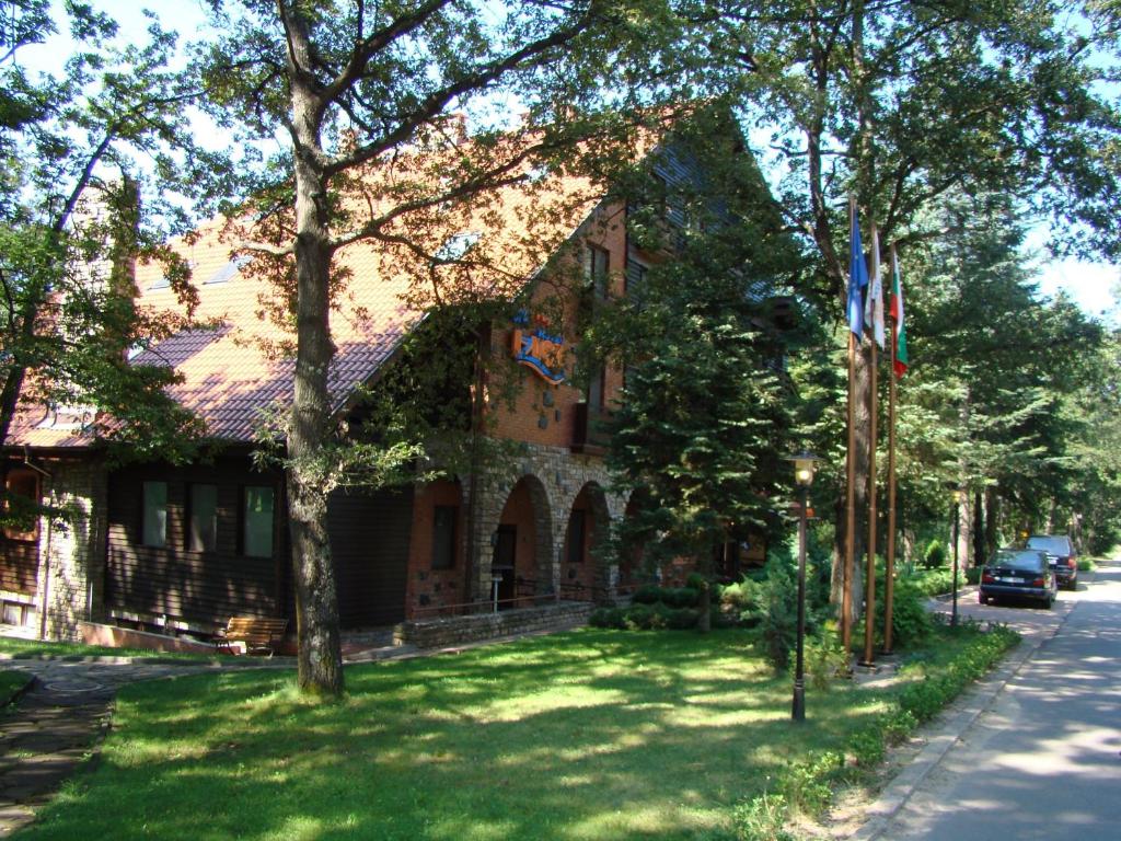 una casa en una calle con césped verde delante de ella en Hotel Izvor en Starozagorski Bani